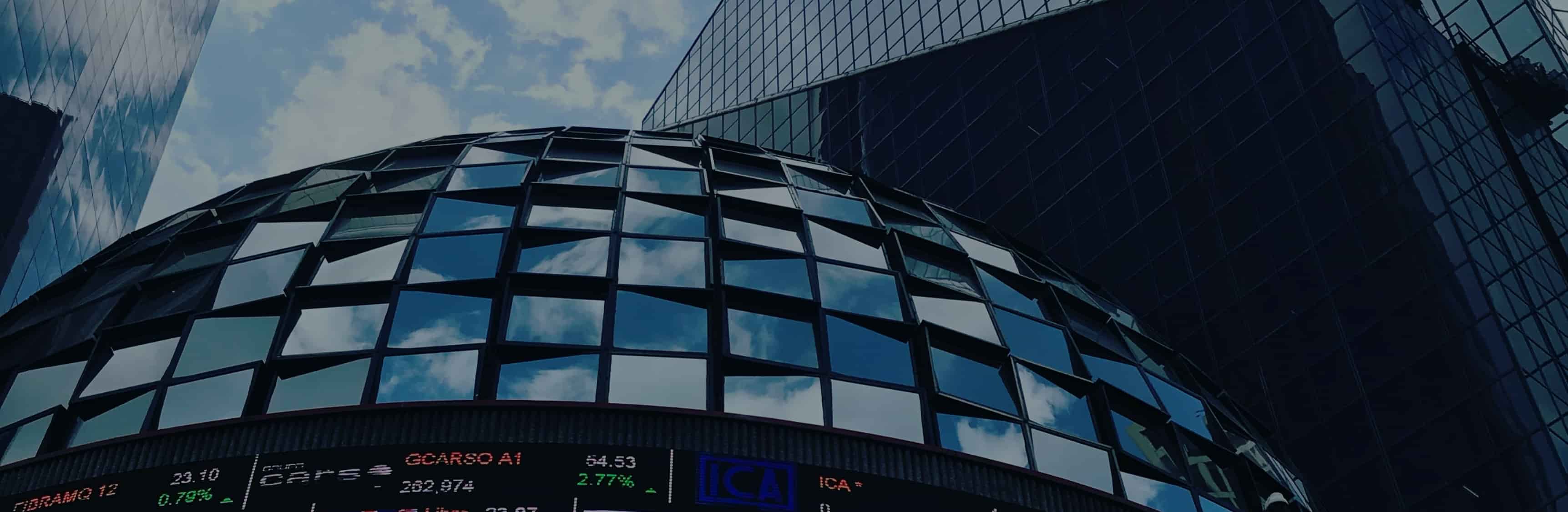 Hero Doble Grado en Administración y Dirección de Empresas y Relaciones Internacionales plano picado de un eficio de oficinas con rotulos de la bolsa